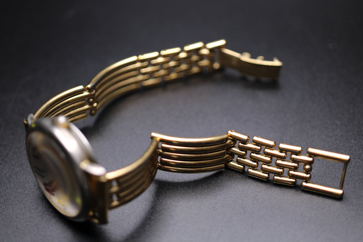 Gold watch strap on a dark background