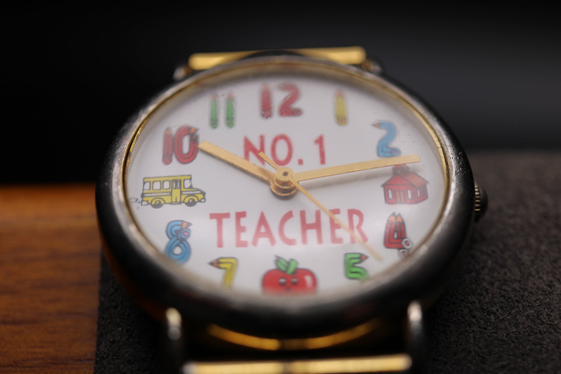 Wristwatch with a colorful 'No. 1 Teacher' design on the dial.